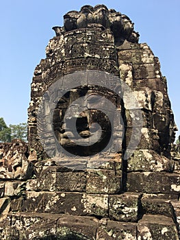 Angkor Wat in Siem Reap, Cambodia. Stone faces carved in the ancient ruins of Bayon Khmer Temple