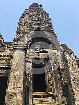 Angkor Wat in Siem Reap, Cambodia. Stone faces carved in the ancient ruins of Bayon Khmer Temple