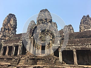 Angkor Wat in Siem Reap, Cambodia. Stone faces carved in the ancient ruins of Bayon Khmer Temple