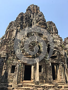 Angkor Wat in Siem Reap, Cambodia. Stone faces carved in the ancient ruins of Bayon Khmer Temple