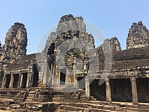 Angkor Wat in Siem Reap, Cambodia. Stone faces carved in the ancient ruins of Bayon Khmer Temple