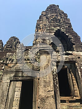 Angkor Wat in Siem Reap, Cambodia. Stone faces carved in the ancient ruins of Bayon Khmer Temple