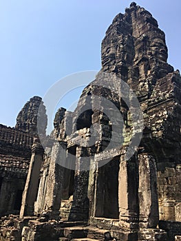 Angkor Wat in Siem Reap, Cambodia. Stone faces carved in the ancient ruins of Bayon Khmer Temple