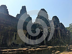 Angkor Wat in Siem Reap, Cambodia. Stone faces carved in the ancient ruins of Bayon Khmer Temple