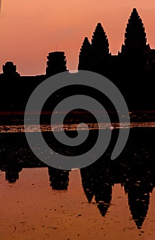 Angkor Wat at sunrise across the lake, reflected in water