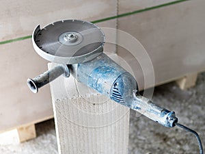 Angle grinder with disc for concrete on the grey brick.