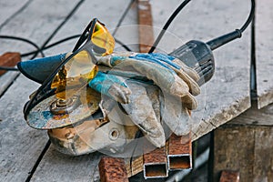 Angle grinder, safety goggles, gloves, a piece of pipe. Worker tools