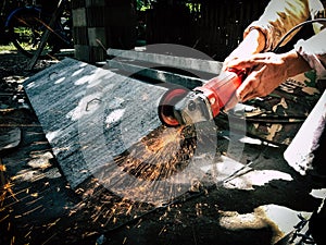 Angle grinder sparks angle grinder cutting steel. A worker cutting steel in concrete sheet with grinder.
