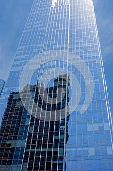 Angle view of glass skyscraper in downtown Chicago with blue sky in the background