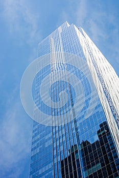 Angle view of glass skyscraper in downtown Chicago with blue sky in the background