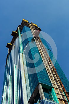 Angle view of glass skyscraper under construction in Chicago downtown with blue sky in the background