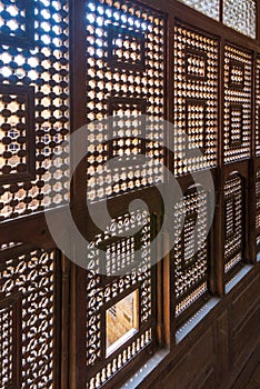 Interleaved wooden ornate windows - Mashrabiya - in stone wall at abandoned building photo