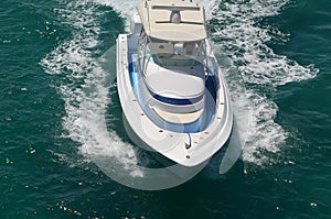 Angled elevated head on view of a white and blue sport fishing boat
