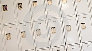An angled photo of a row of tan lockers in an education setting.