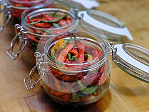 Angled view of open glass jars with canned hot pepper. The jar is prepared for clogging after pickling. The culinary delicacy of