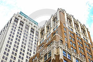 Angled view up at ornate old tall office buildings from street level