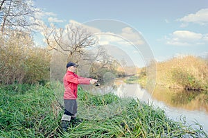 Angler athlete casts spinning rod into the river