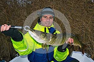 Angler with autumn pike trophy