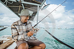 angler checking the reel before fishing with a fishing rod