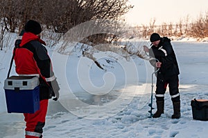 The angler drills a hole in the ice for ice fishing