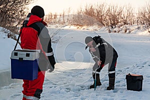 The angler drills a hole in the ice for ice fishing