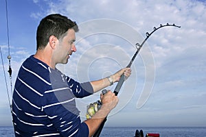 Angler fisherman fighting big fish rod and reel photo