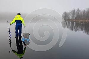 Angler with fishing equipment on the ice