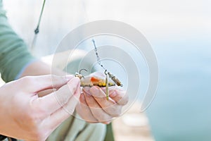 Angler fixing lure at hoof of fishing rod