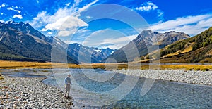 An Angler fly fishing for trout on the Ahuriri river, surrounded by mountains