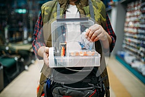 Angler holds box with hooks and baubles