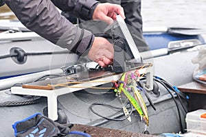 An angler installs an echo sounder on board the boat photo