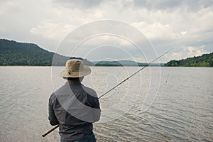 Angler man with fishing rod for fishing at the lake