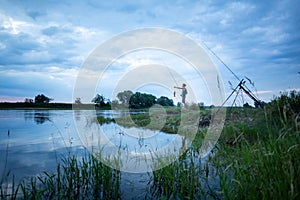 Angler on a river bank caught a fish