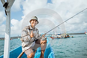 angler smiling with thumbs up on a small fishing boat