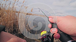 Angler spinning fish on the river - firt person view