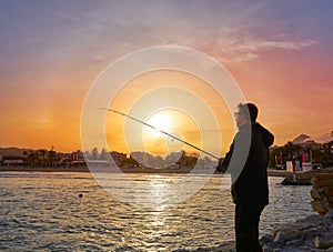 Angler with spinning rod fishing in Mediterranean