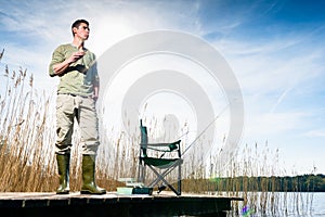 Angler standing on jetty having food for breakfast