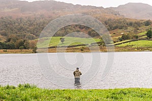 Angler in waders waiting for a catch at Watendlath photo