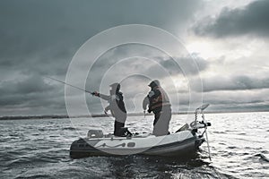 Anglers catch fish from a boat with a spinning rod