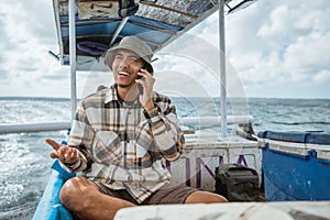 anglers chat on cell phones during a break sitting