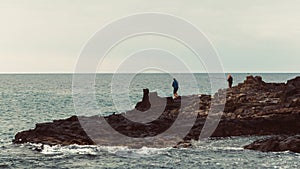 Anglers are fishing on rocky coastline