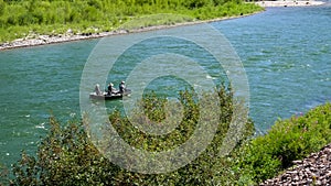 Anglers fly fishing from a drift boat on the snake river