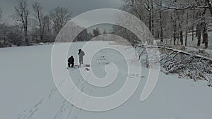 Anglers on the ice catch fish, aerial view