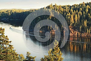 Anglers  launch near island with granite rocks and woods in North Europe, Baltic sea, gulf of Finland. Clean nordic nature and