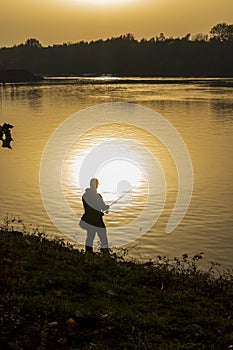 Anglers in romantic mood on the banks of a river at sunset