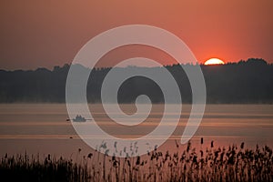 Anglers rowing a boat across the lake in Åšwierklaniec.