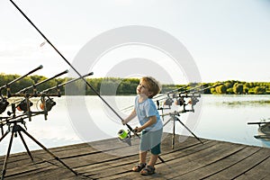 Angling child with fishing rod on wooden pier