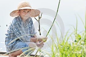 Angling teenage boy with handmade green twig fishing rod