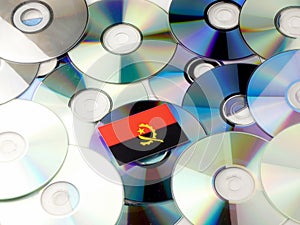 Angolan flag on top of CD and DVD pile on white