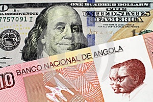An Angolan kwanza bank note with an American one hundred dollar bill